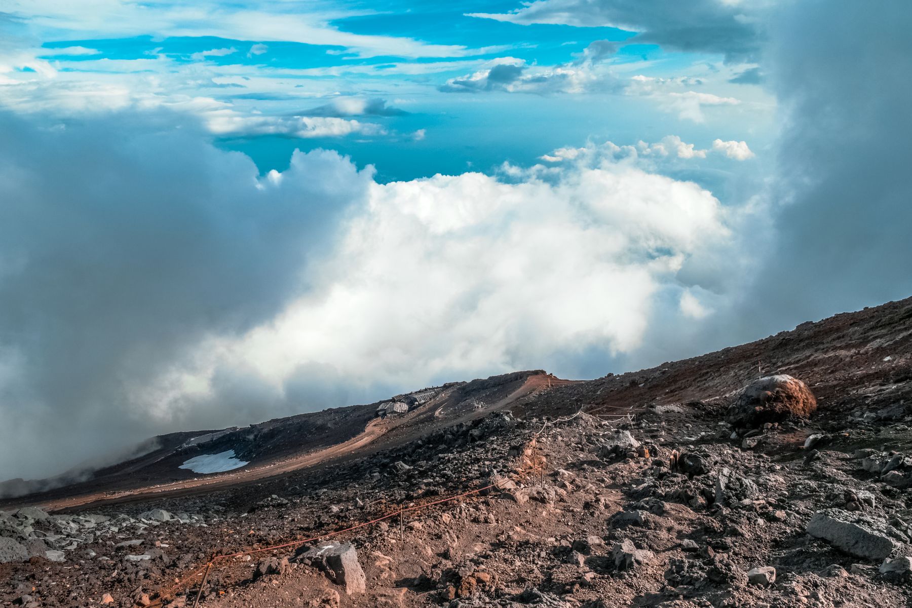 The rim of the Mount Fuji crater above a sea of cloud