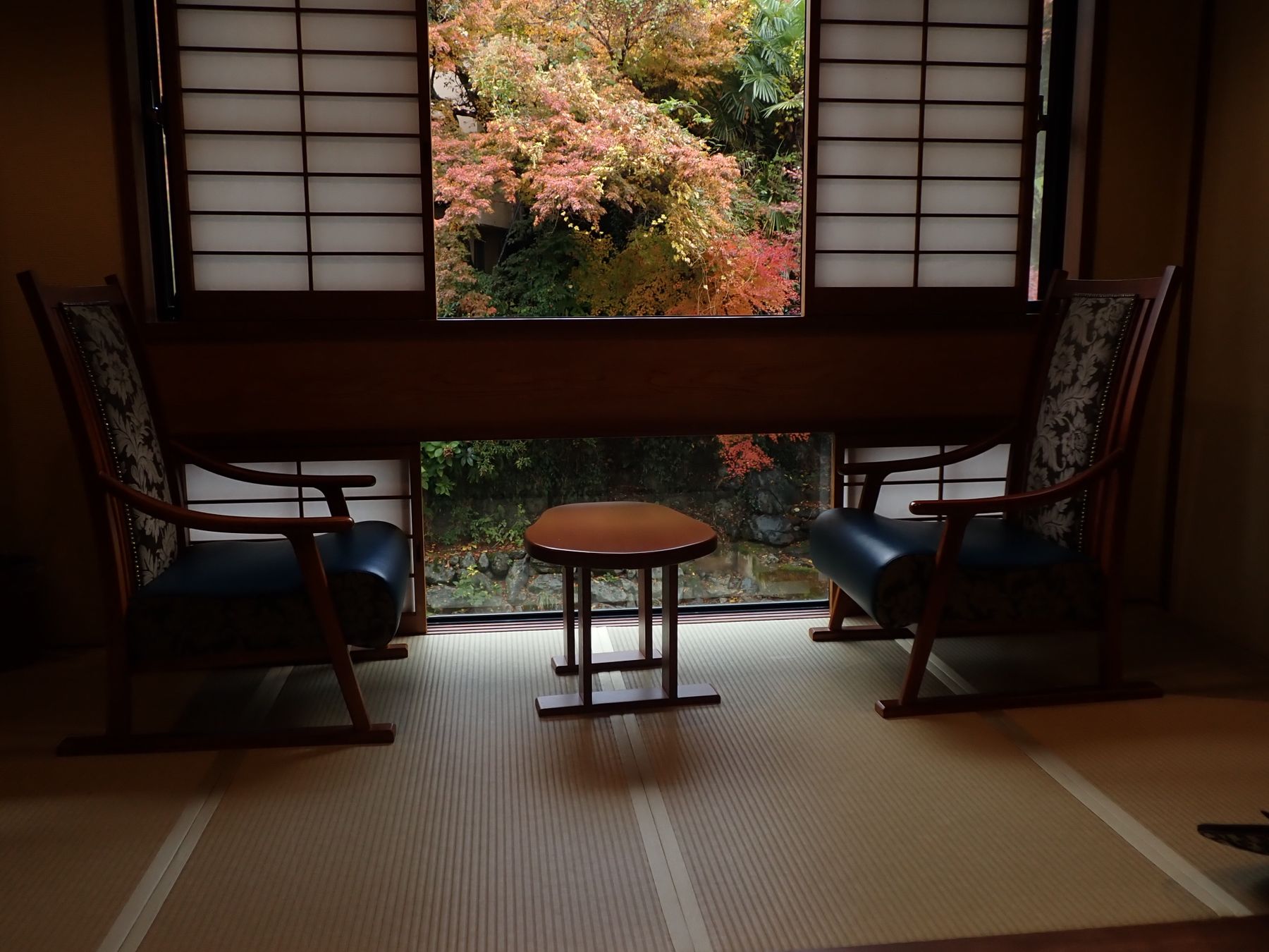 A traditional tatami room with two low chairs facing a garden